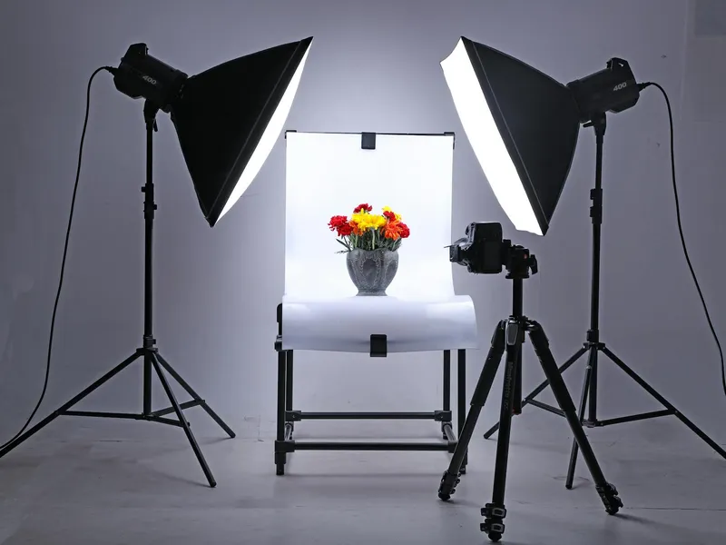 Góc chụp sản phẩm với đèn studio và bình hoa trên nền trắng